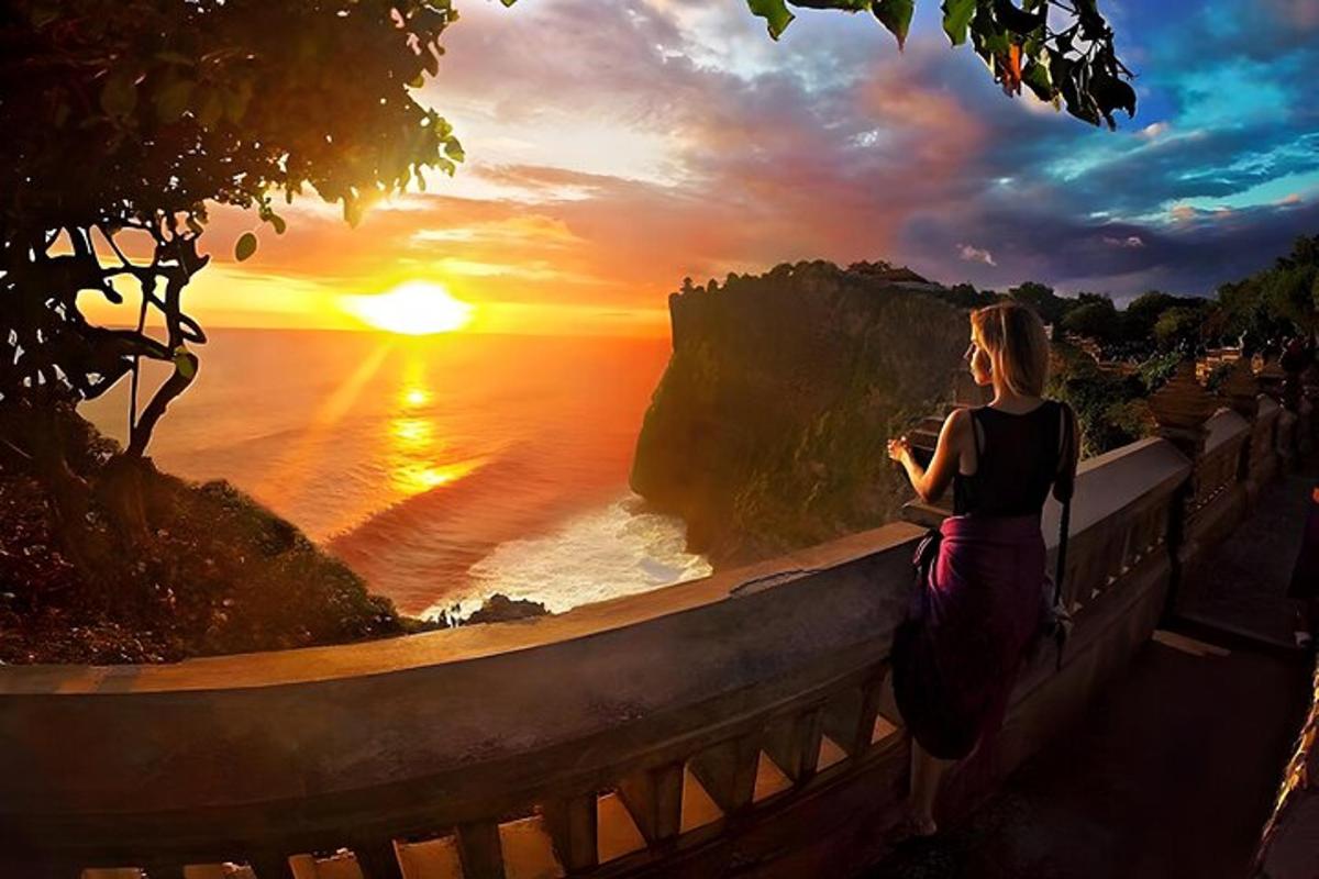 Una mujer parada en un muro mirando la puesta de sol.