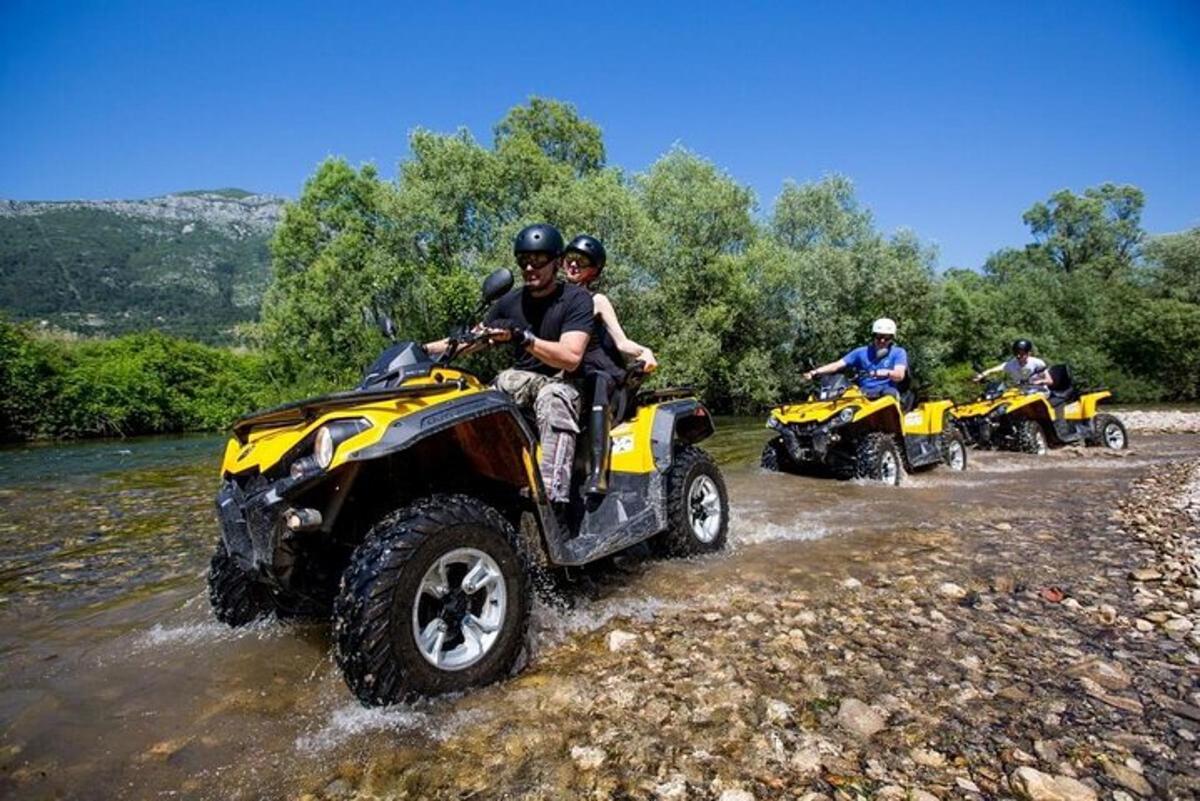 Μια ομάδα ανθρώπων που οδηγούν ATV σε ένα ποτάμι