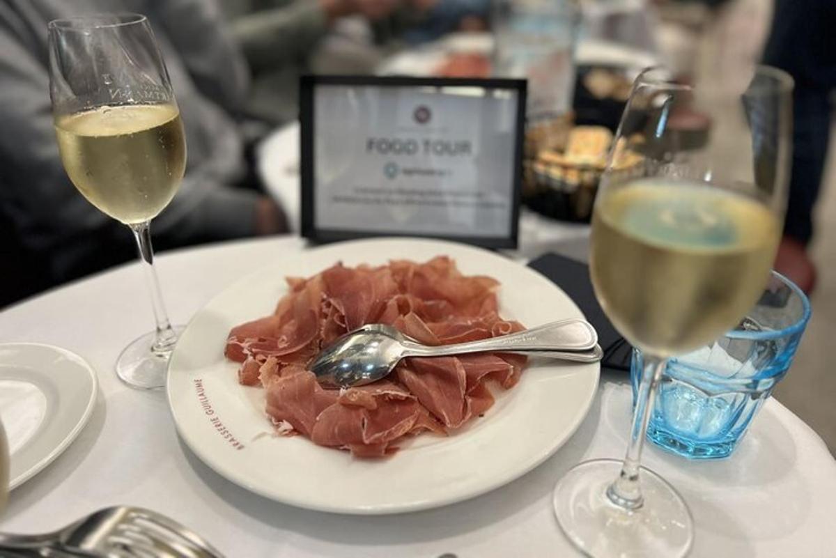Un plato de comida en una mesa con dos copas de vino.