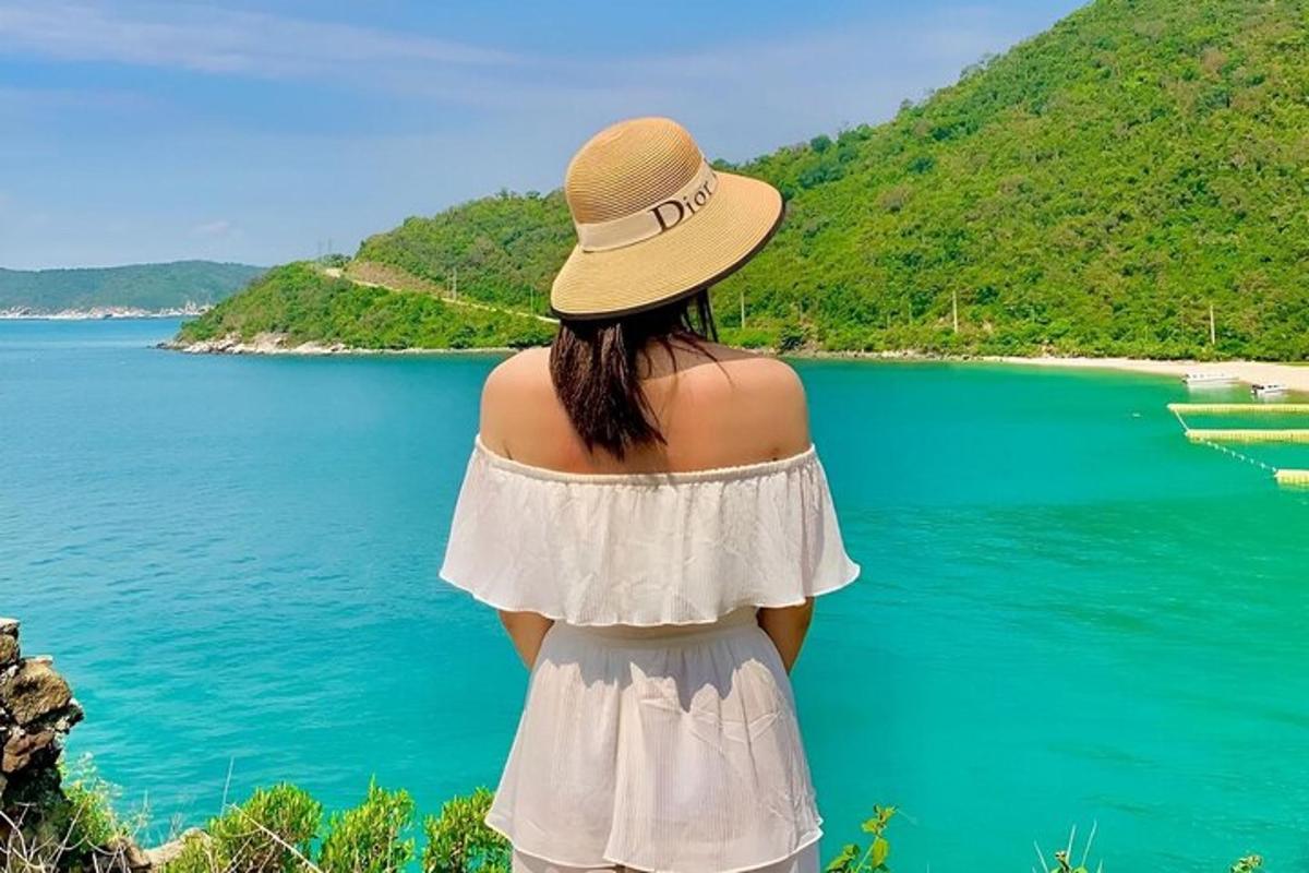 uma mulher usando um chapéu olhando para um lago