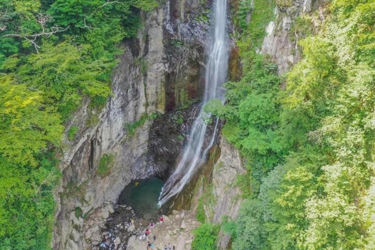 an aerial view of a waterfall on the side of a mountain
