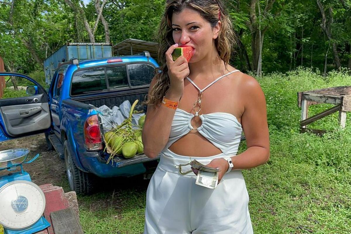 eine Frau in einem weißen Kleid, die einen Apfel isst