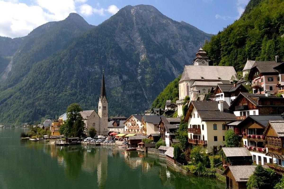 uma cidade em um lago com montanhas ao fundo