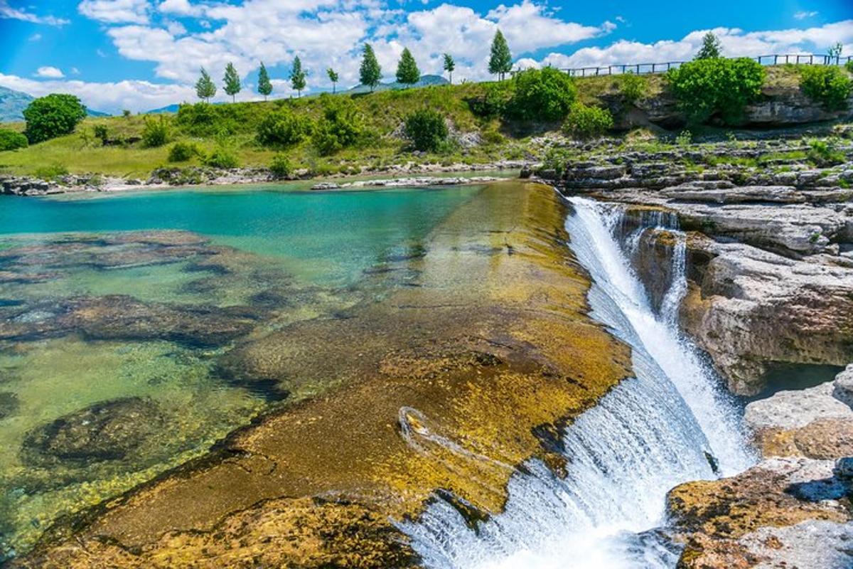 una cascada al lado de un cuerpo de agua