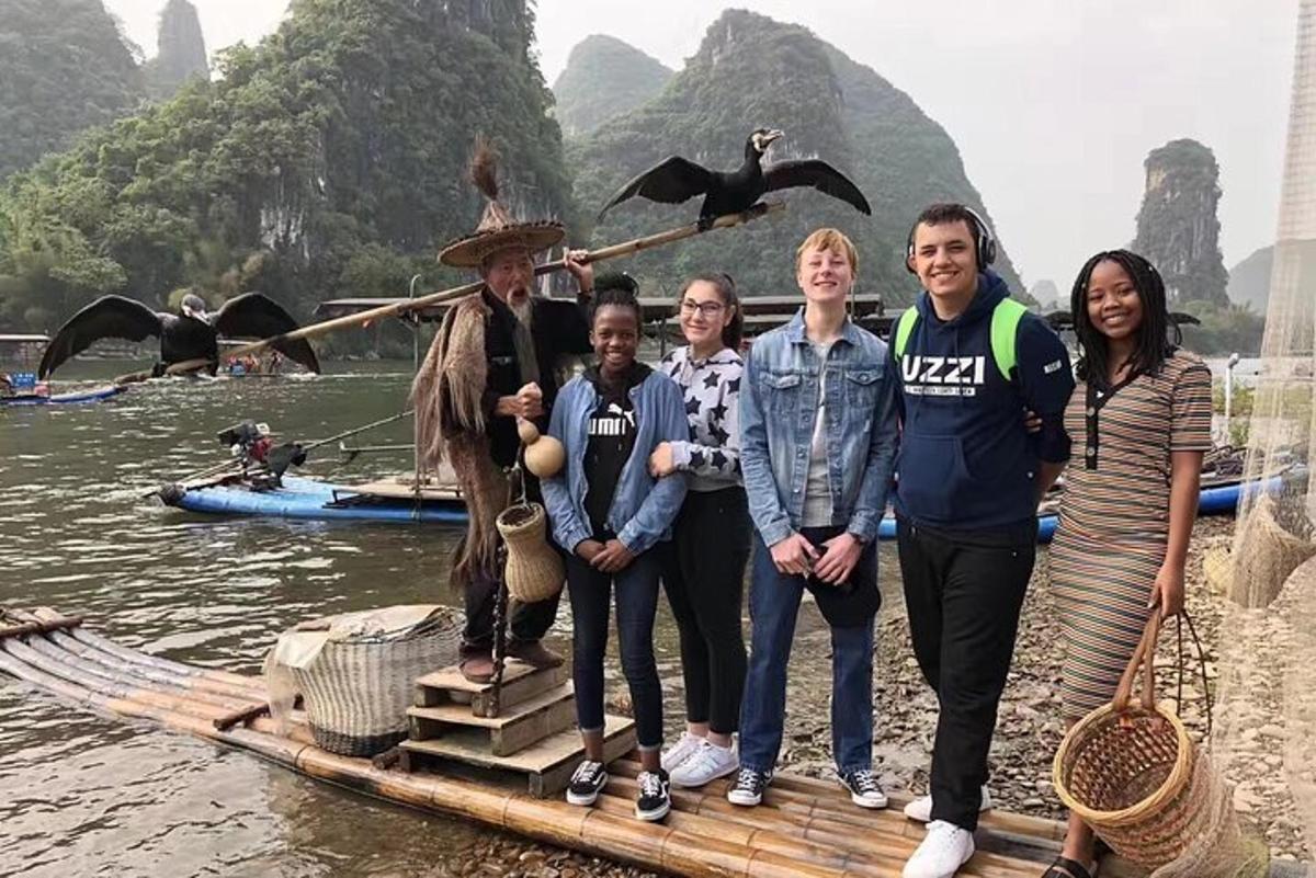 a group of people standing on a raft in the water