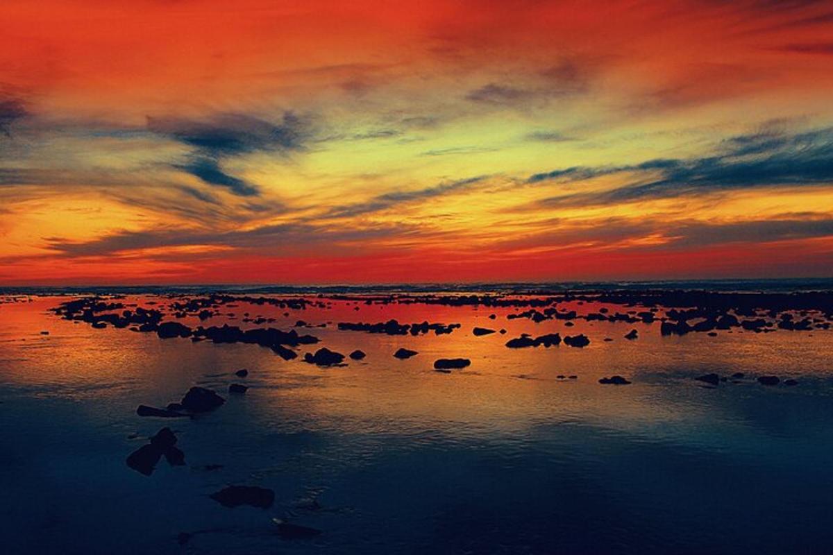 hoàng hôn trên một vùng nước có đá