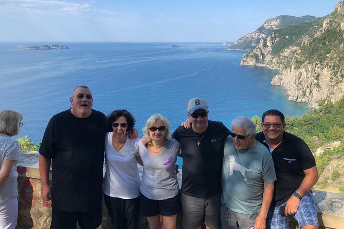 Μια ομάδα ανθρώπων ποζάρει για μια φωτογραφία κοντά στον ωκεανό