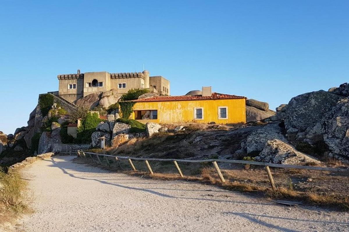 una casa en un turó amb un castell al fons