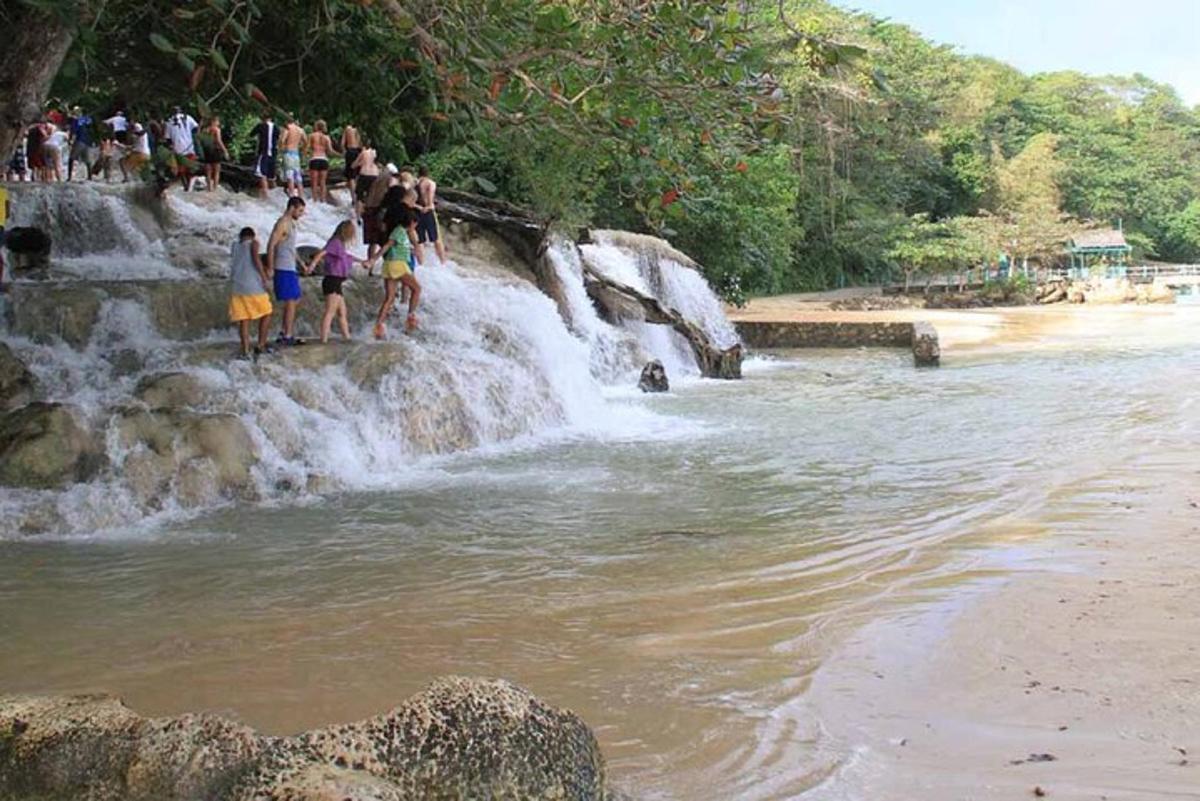 un gruppo di persone in piedi sul bordo di una cascata