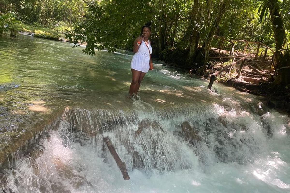 uma mulher em pé no topo de uma cachoeira