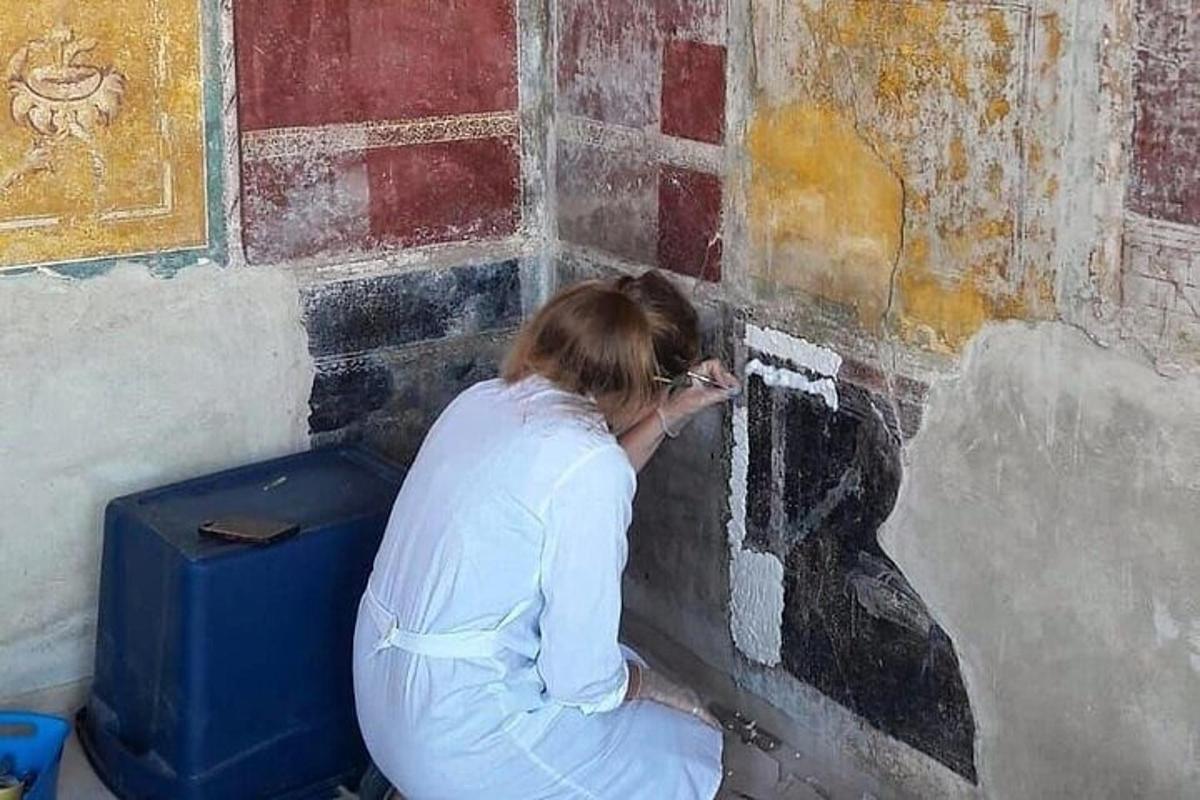 žena maluje zeď na zeď