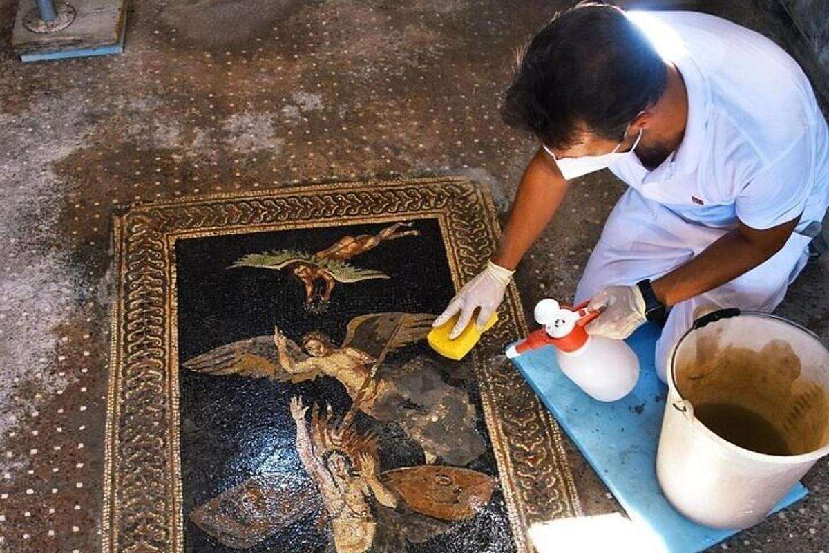 a man painting a picture of a cross on a floor