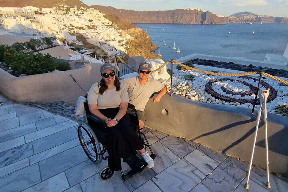un uomo e una donna su una sedia a rotelle seduti su una sporgenza con l'oceano