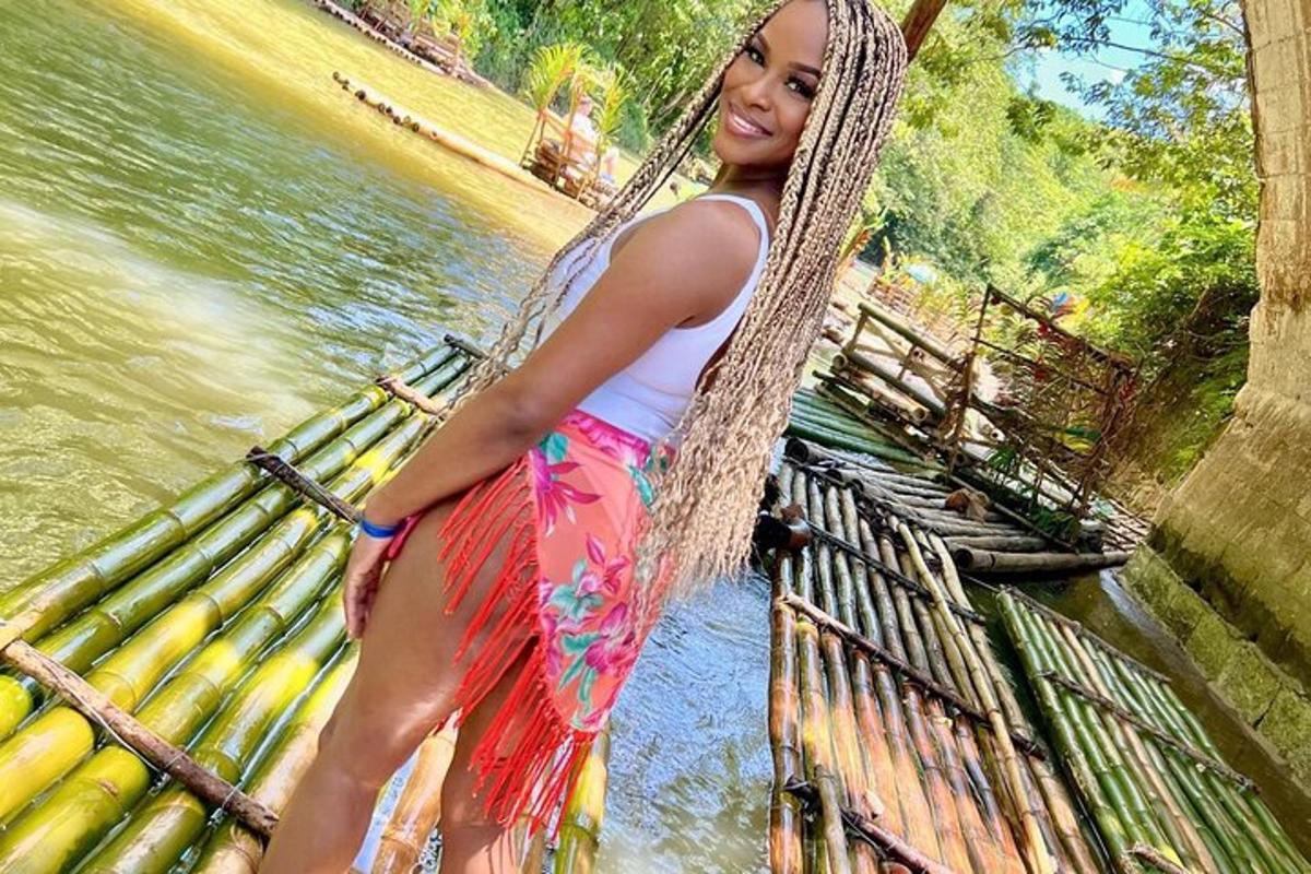 a woman in a dress standing on a rope bridge