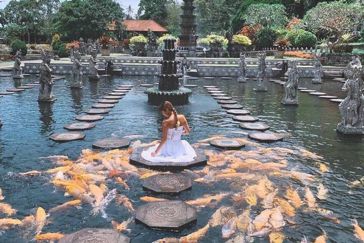 una donna in abito bianco seduta nell'acqua