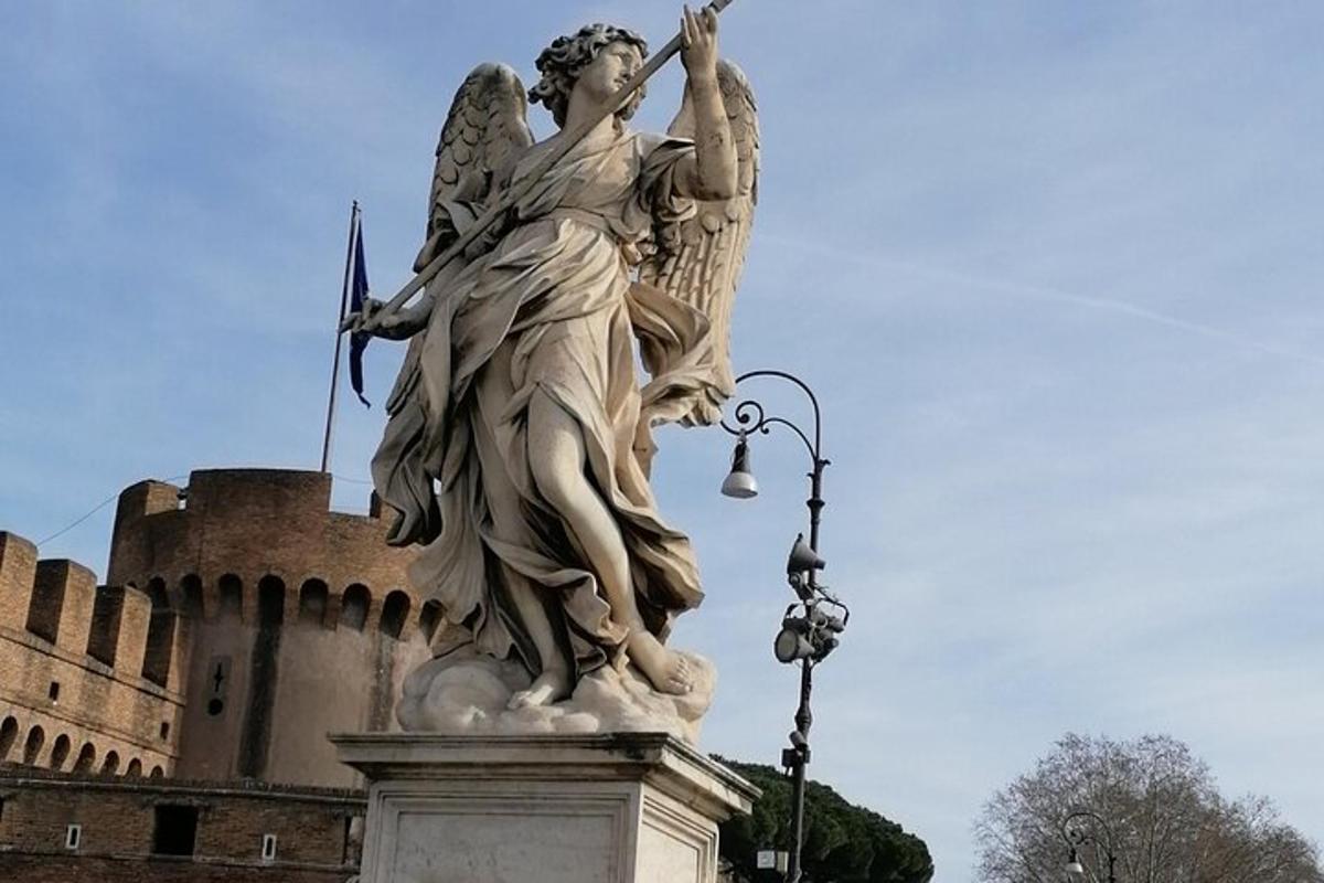 eine Statue eines Engels, der vor einem Schloss steht