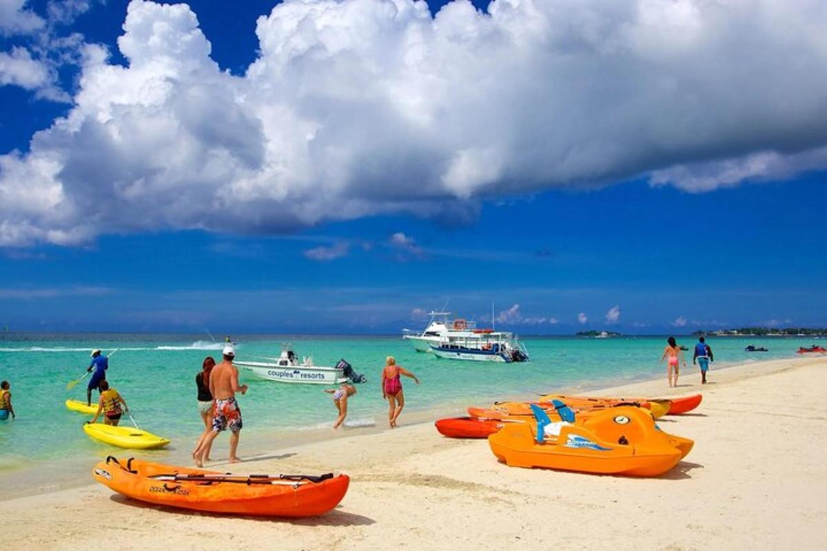 un gruppo di persone su una spiaggia con barche in acqua