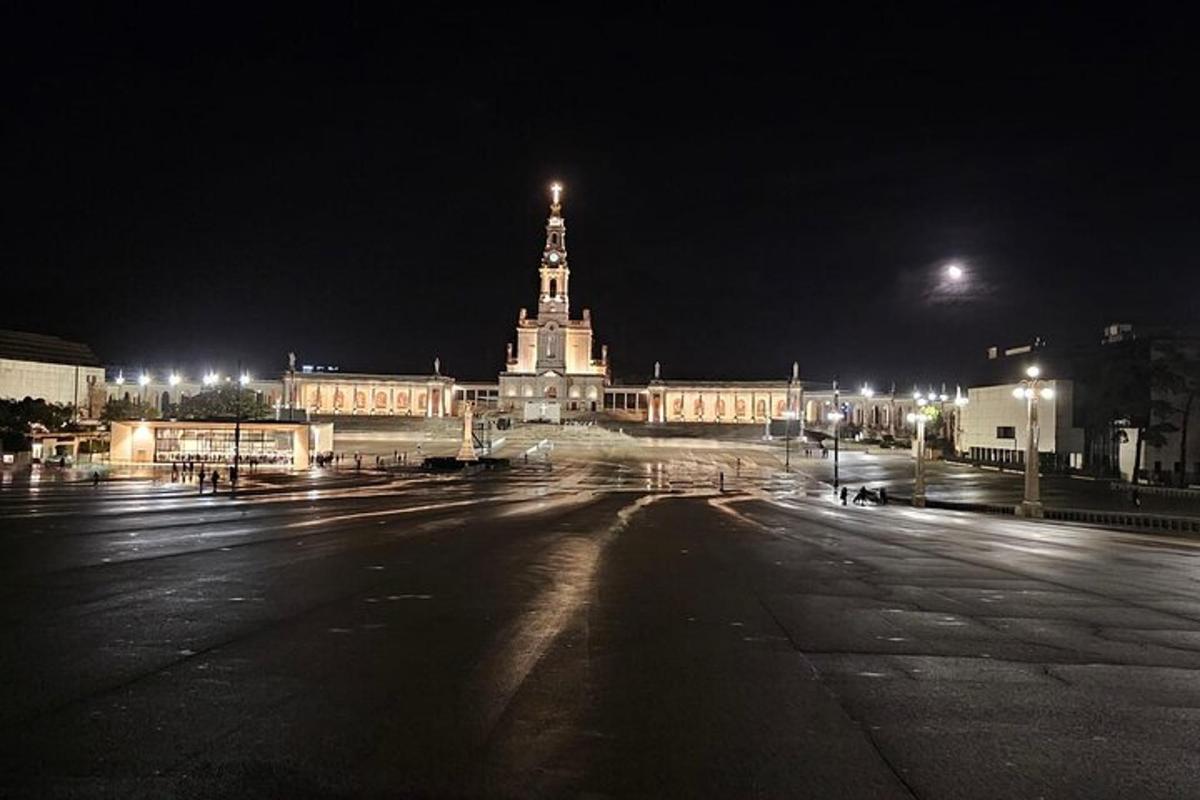 Un gran edificio con una torre de reloj por la noche.