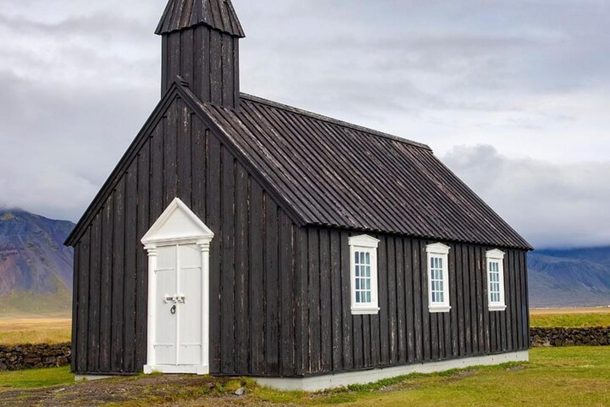 svört kirkja með hvítum hurðum og turni
