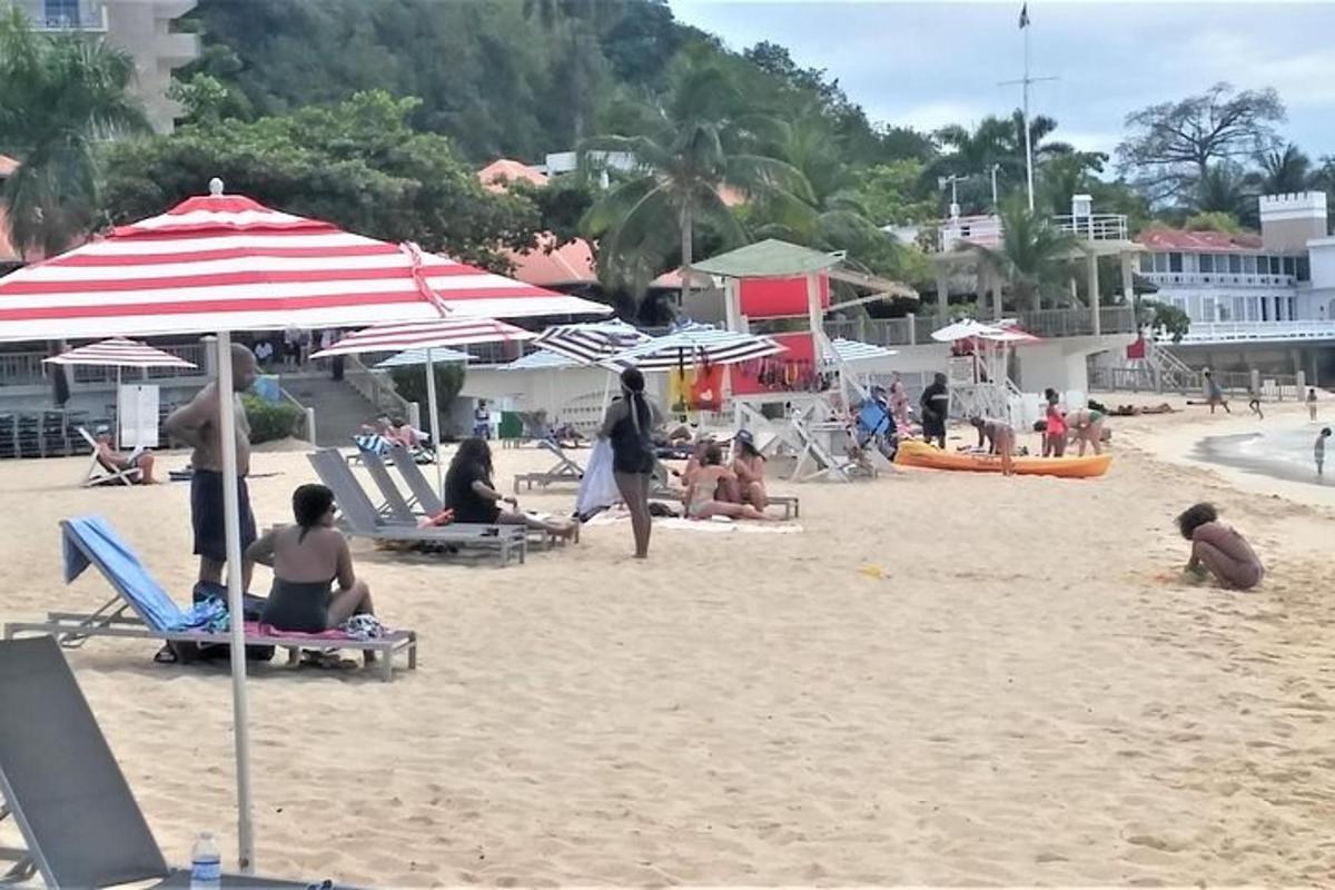 μια ομάδα ανθρώπων που κάθονται σε μια παραλία με ομπρέλες