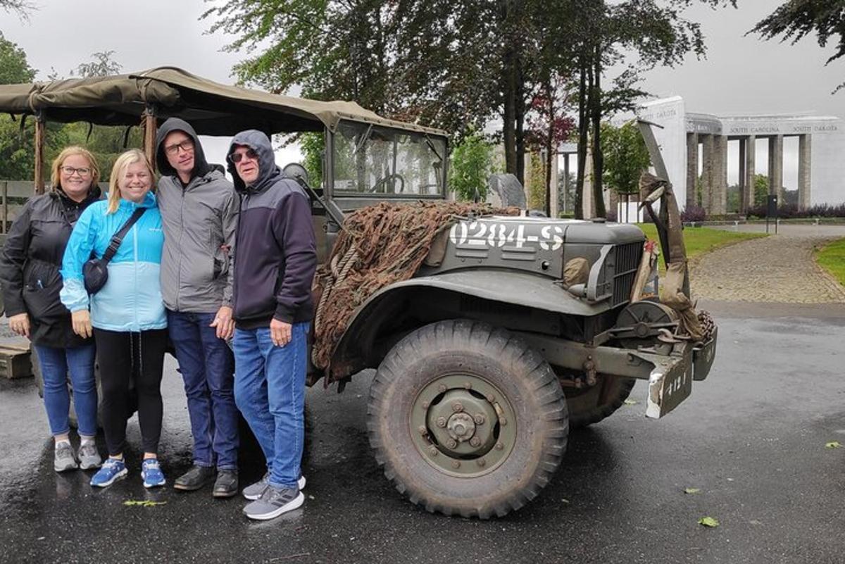 skupina lidí stojící před vojenským nákladním vozem