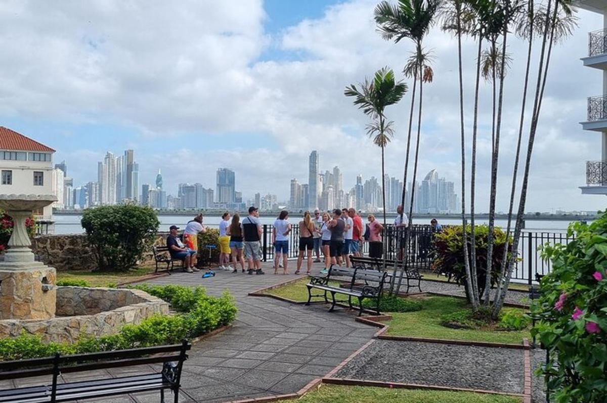a group of people standing in a park with a city skyline