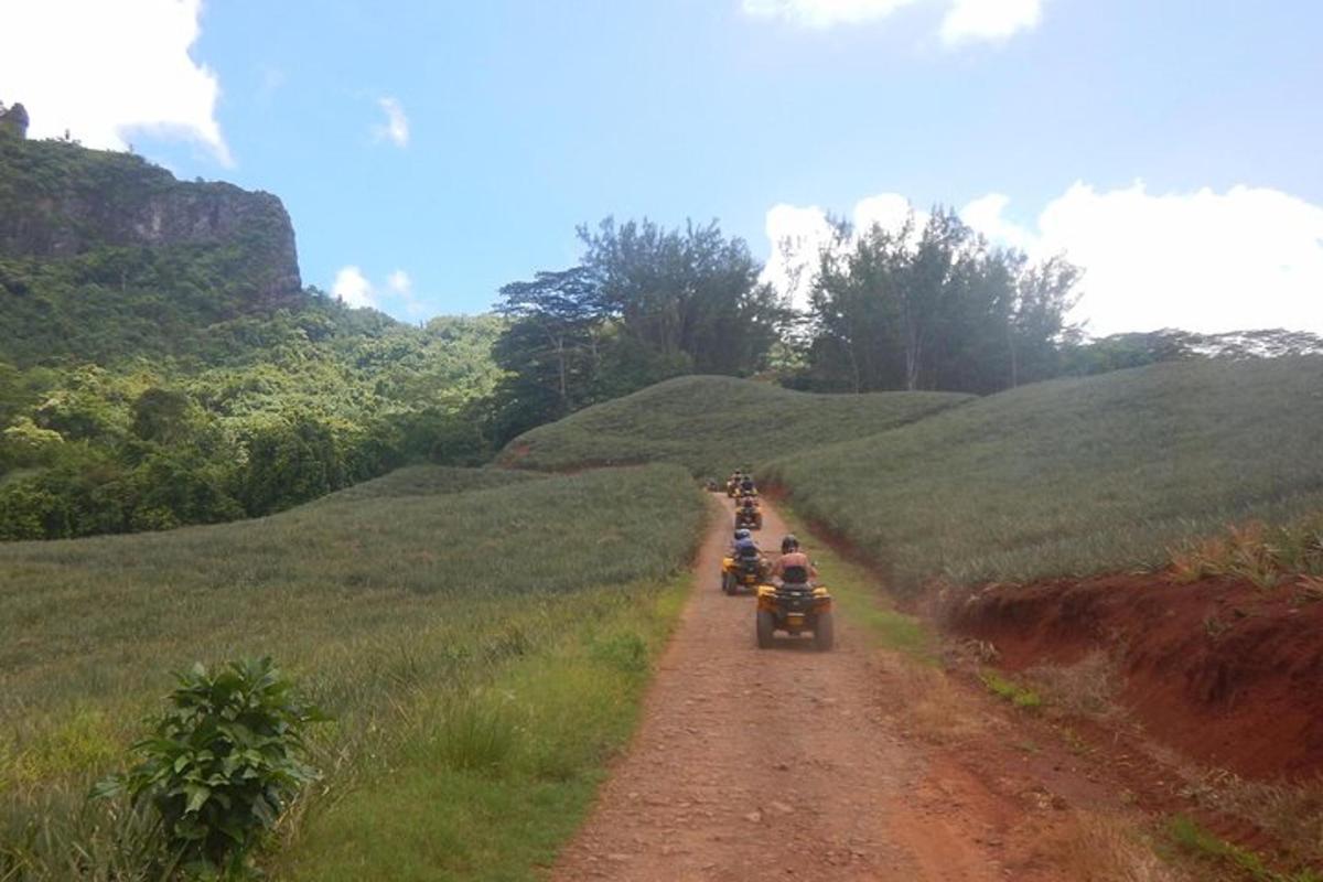 a group of people riding motorcycles down a dirt road