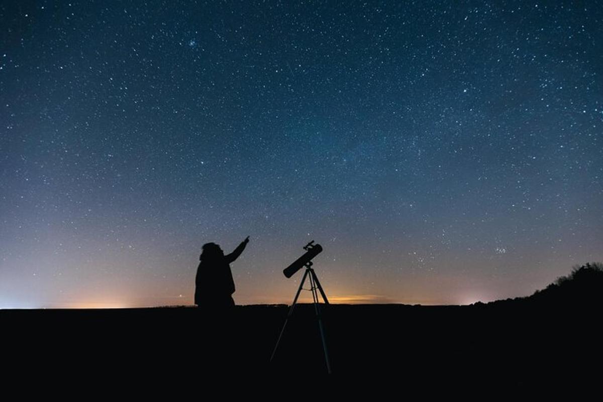 una persona mirant el cel estrellat amb un telescopi