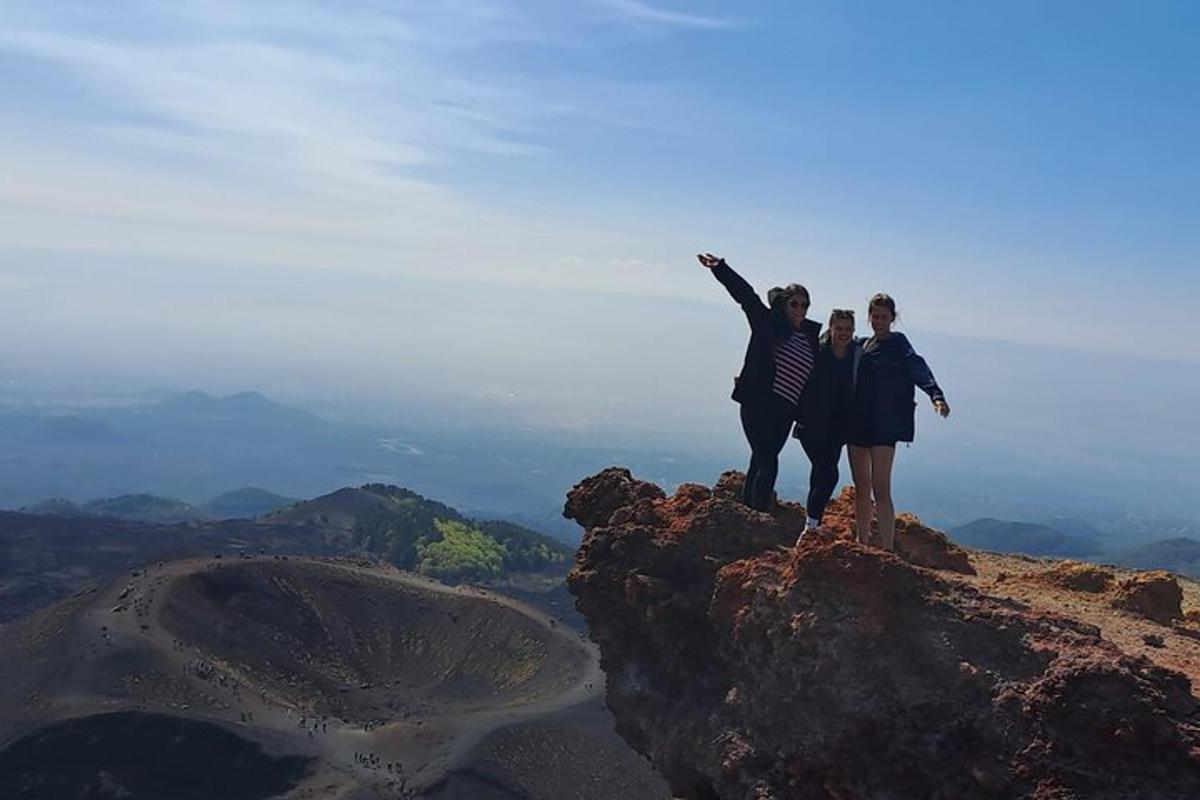 three people standing on top of a mountain