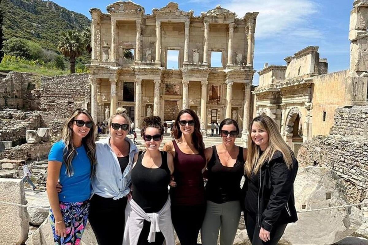 a group of women standing in front of the ruins of the building