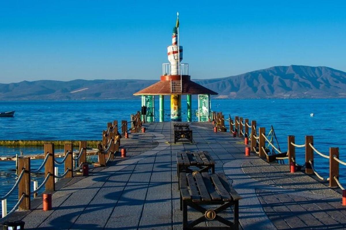 Un muelle con un faro en el agua