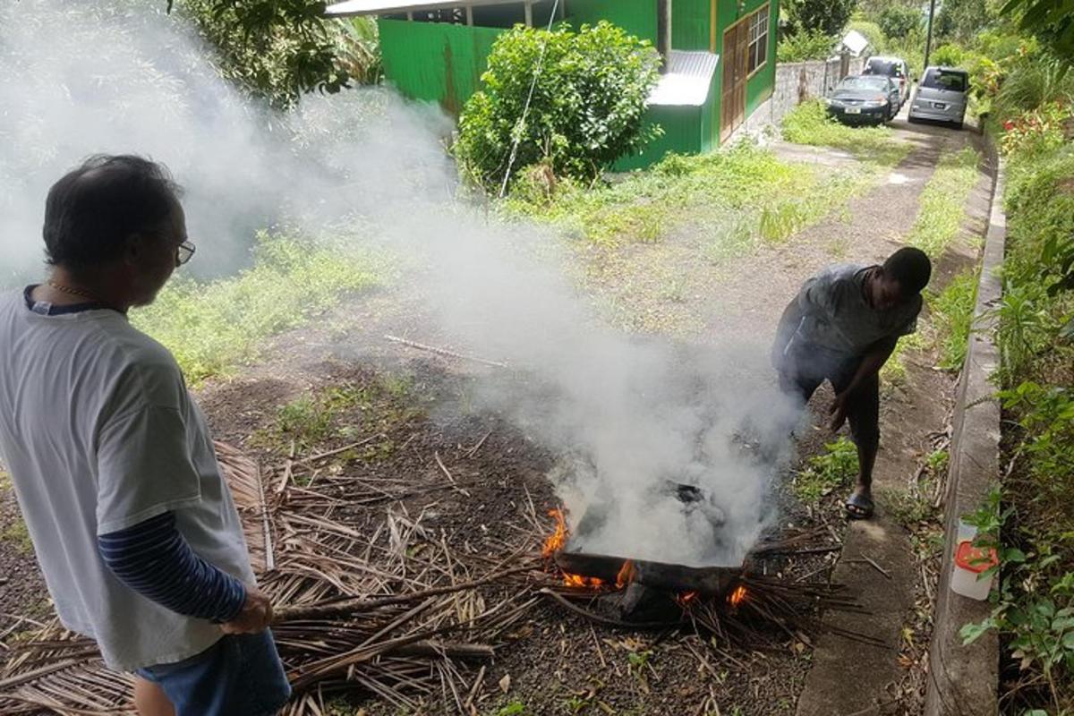 two men are standing around a barbecue grill