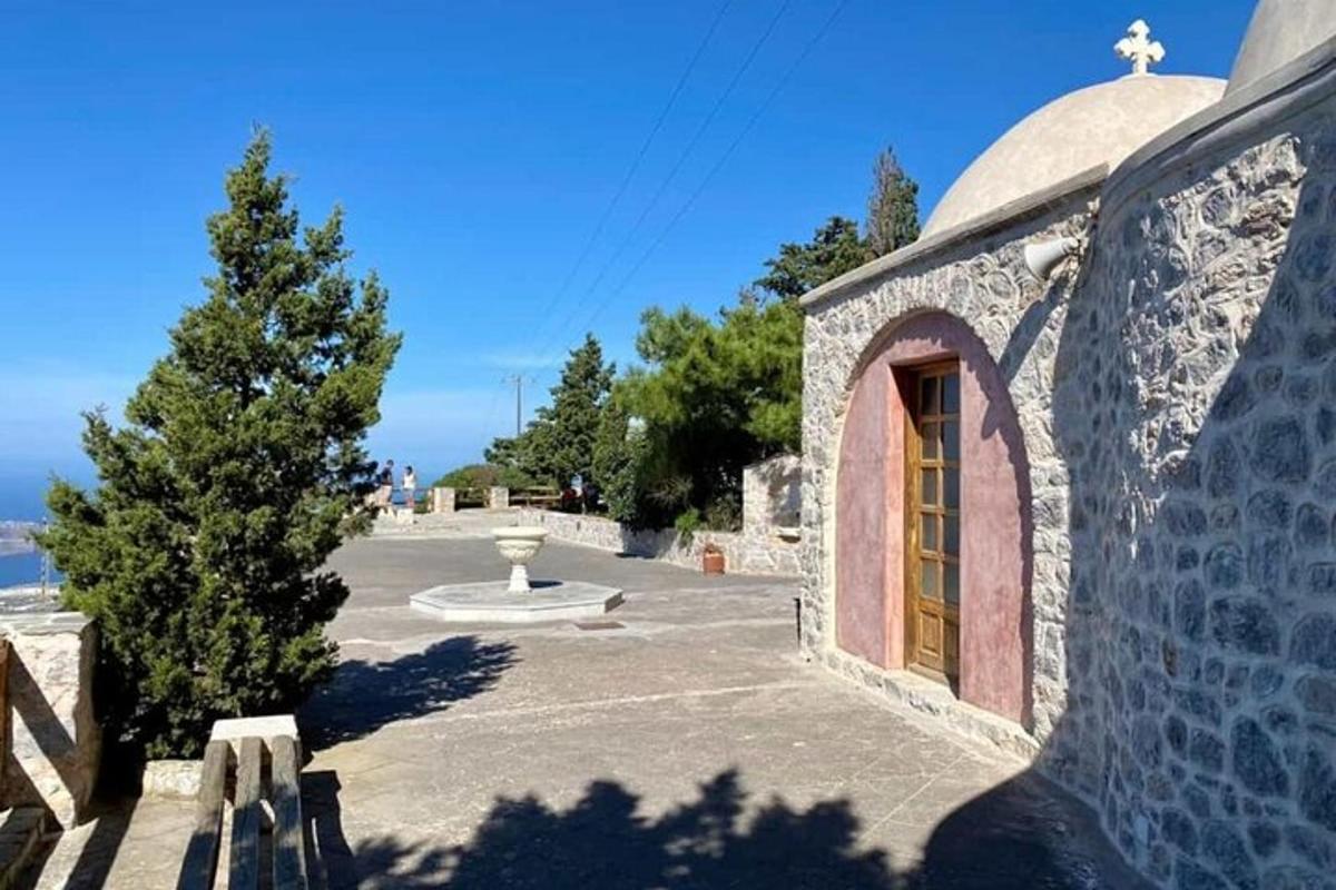 Un edificio de piedra con una puerta y un árbol.
