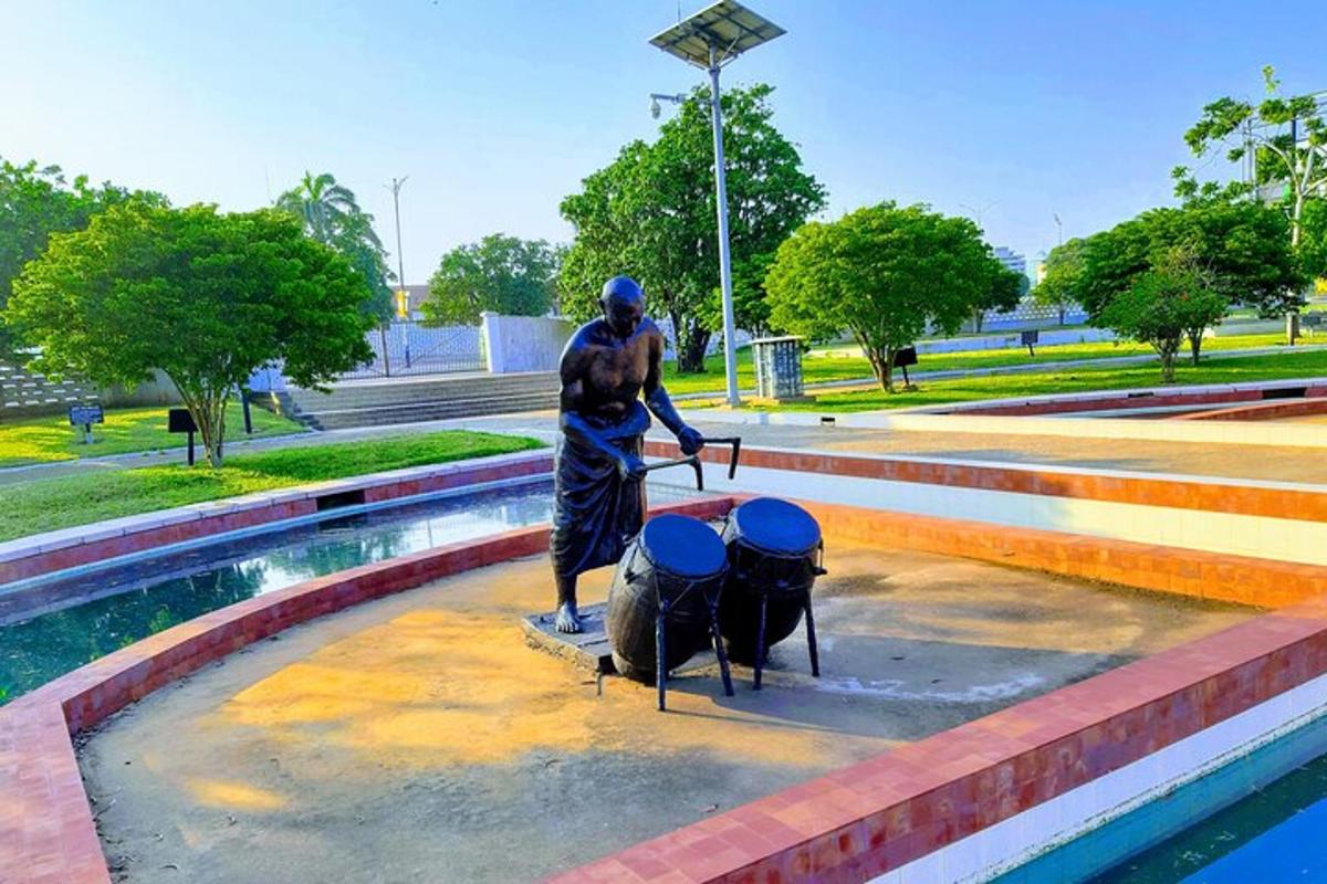 una statua di un uomo in piedi accanto a una fontana