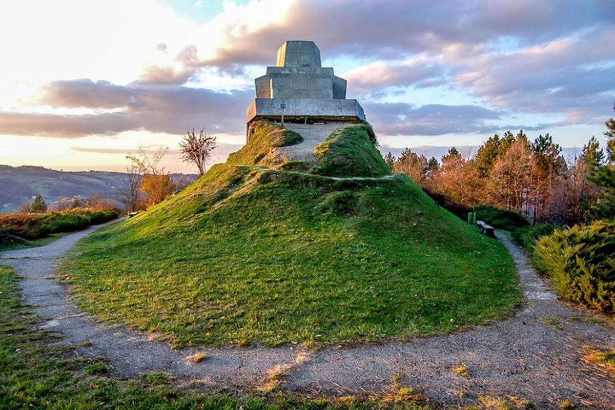 a grassy hill with a monument on top of it