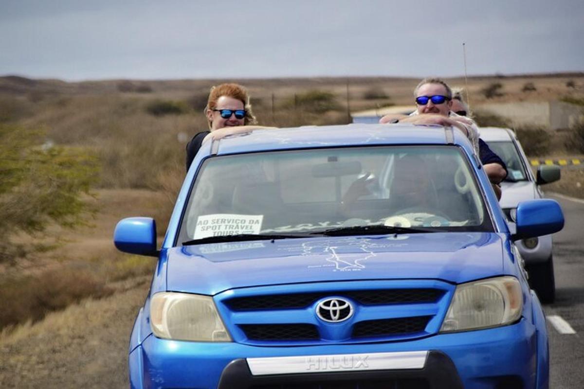 dois homens sentados no teto de um carro azul