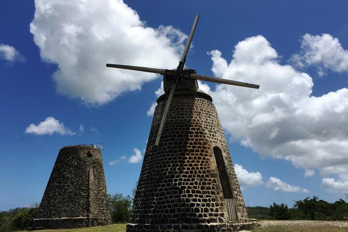 a brick windmill sitting in the middle of a field