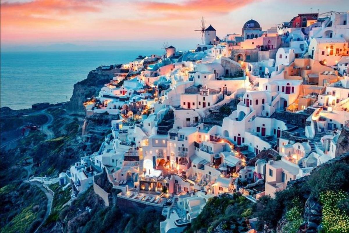 un villaggio sul fianco di una collina con l'oceano