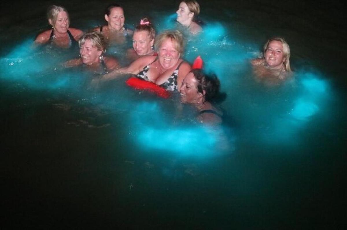 un gruppo di persone in acqua di notte