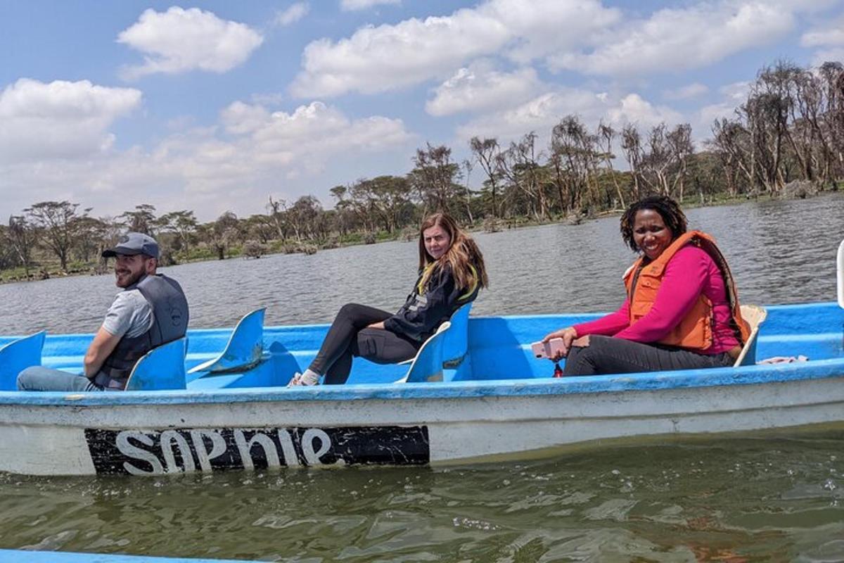 drei Personen sitzen in einem blauen Boot auf dem Wasser