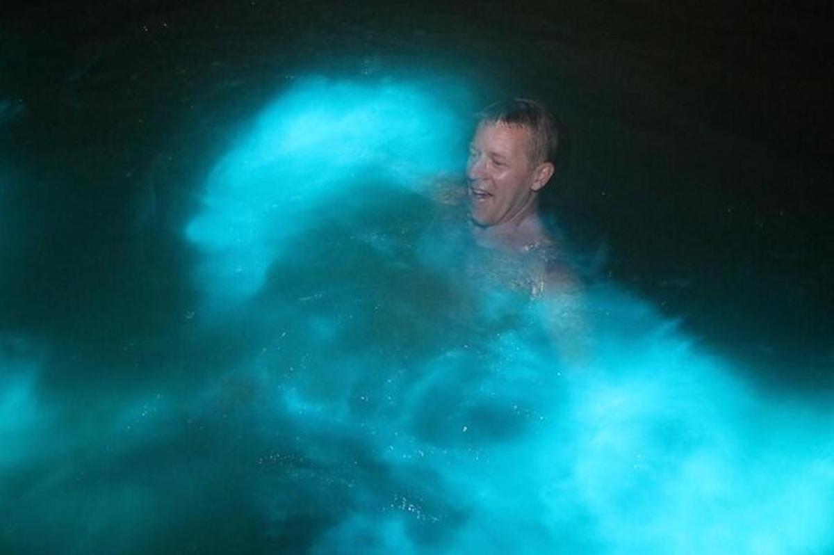 un uomo in una piscina con luci blu
