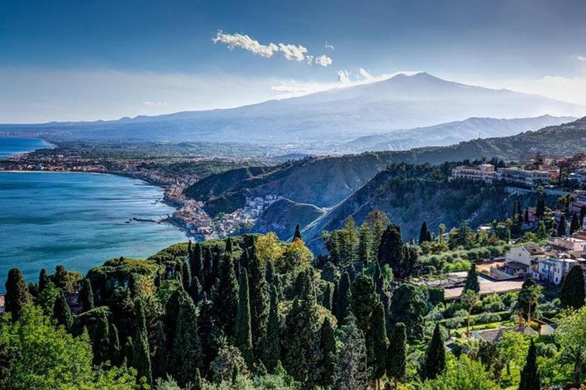 uma vista de uma cidade e do oceano com uma montanha