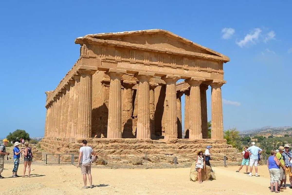 μια ομάδα ανθρώπων που στέκονται μπροστά σε έναν ναό