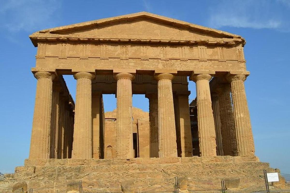 Un edificio alto de piedra con columnas en la parte superior.