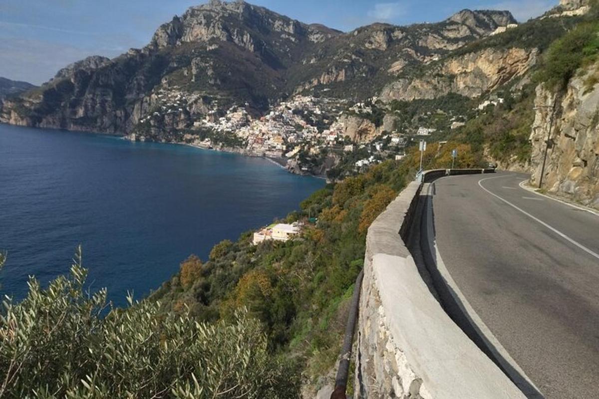 ένας δρόμος δίπλα σε ένα υδάτινο σώμα με βουνά