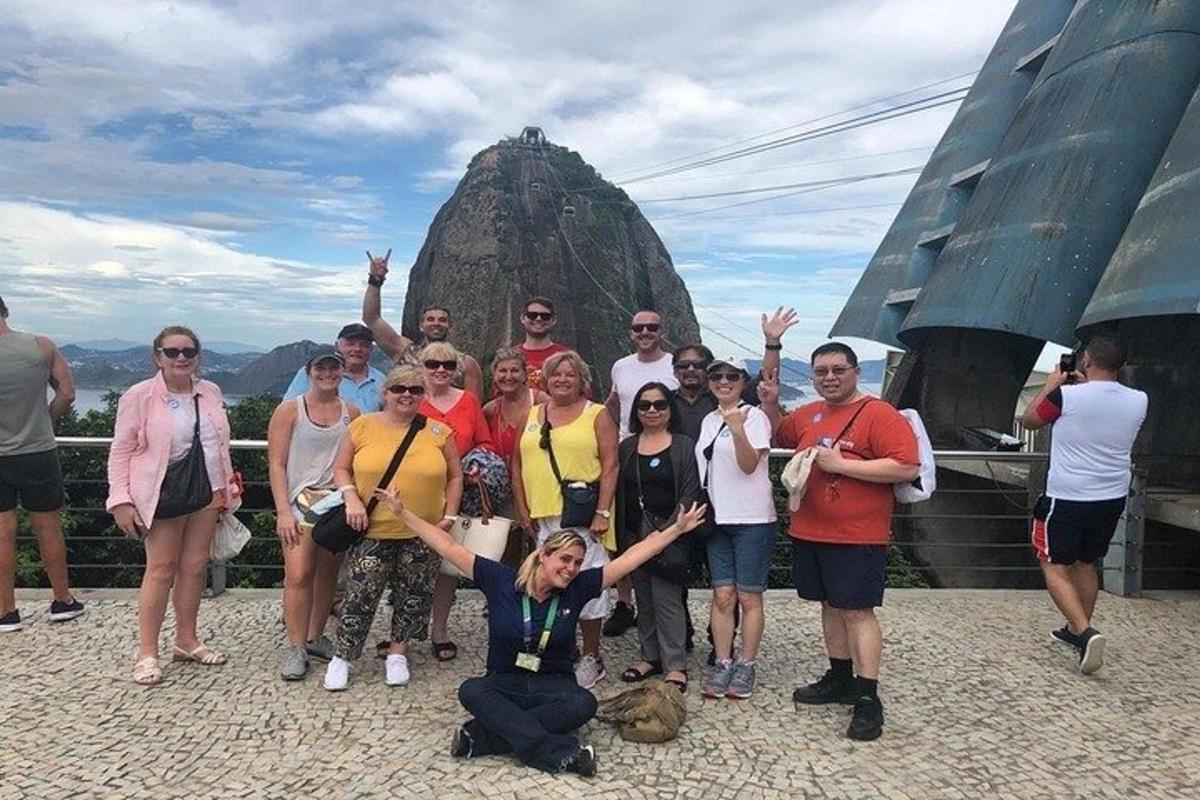 um grupo de pessoas posando em frente a uma rocha