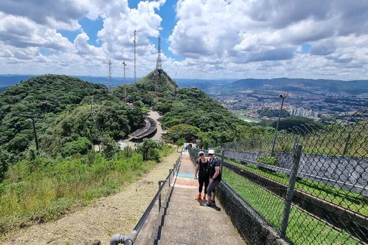 two people walking down a path on a hill