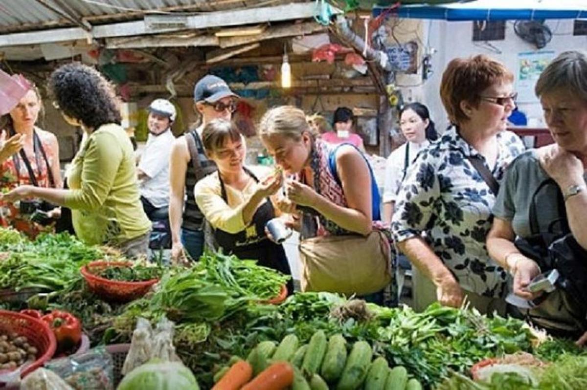 un grup de oameni care stăteau în jurul unei piețe cu legume
