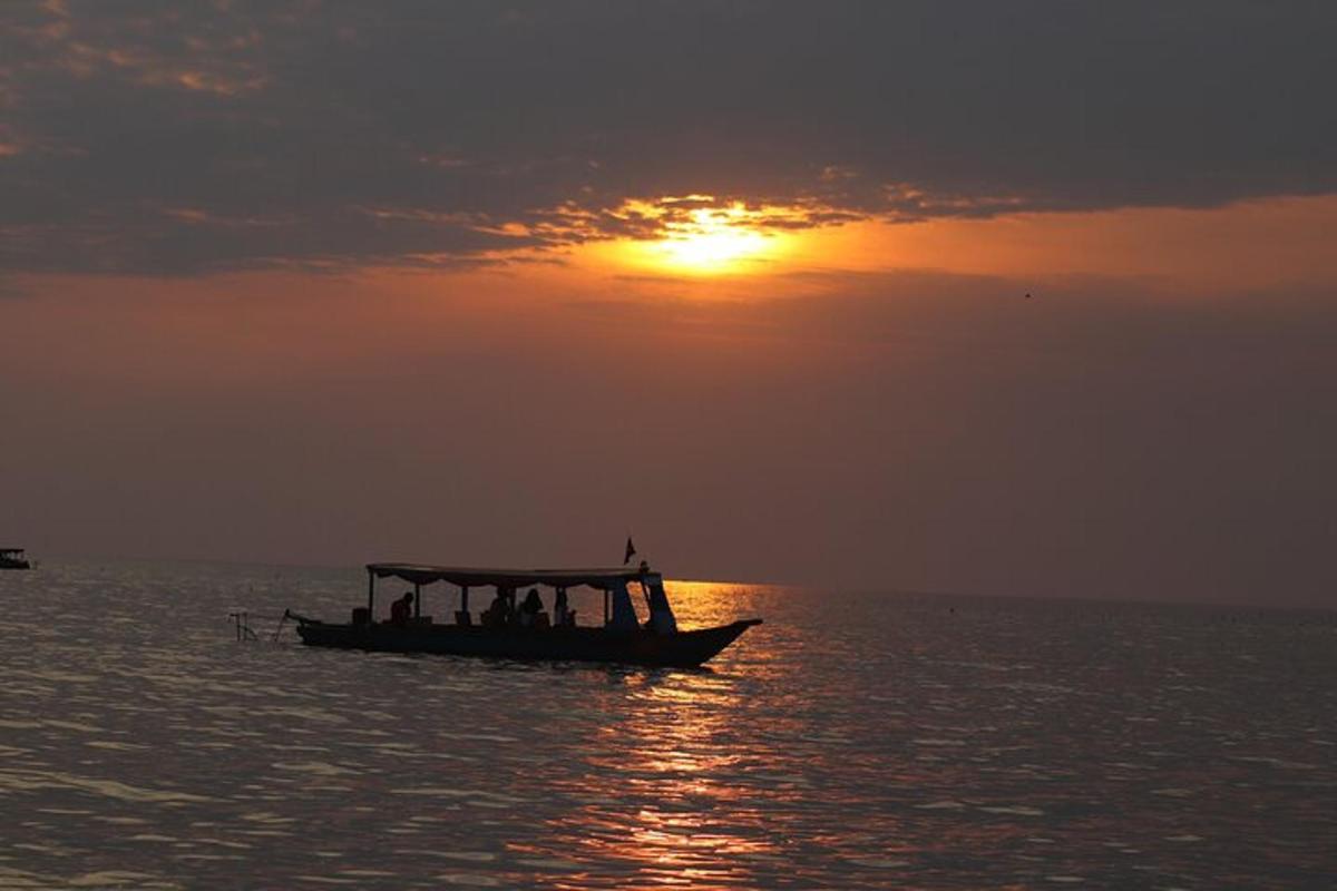 Un barco en el océano con la puesta de sol