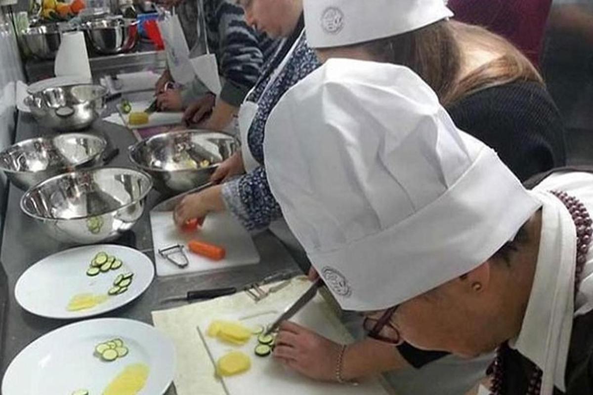 Un grupo de personas en una cocina preparando comida.